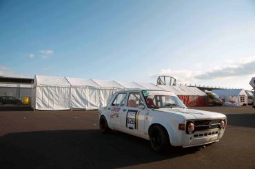 Rennwagen von Michael Stevens, geparkt auf der Rennstrecke mit Zelten im Hintergrund, bei einem Motorsport-Event.