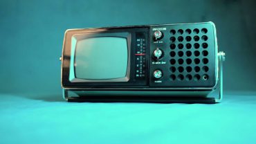 Alter Fernseher im Retro-Stil mit Bildschirm, Knöpfen und Lautsprechern, ideal für Vintage- und Nostalgie-Themen.
