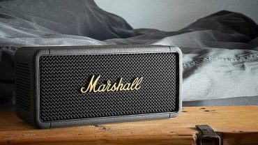 Tragbarer Marshall Bluetooth-Lautsprecher auf Holz, ideal für Musikliebhaber, mit robustem Design und hochwertigem Klang. Perfekt für unterwegs und Zuhause.