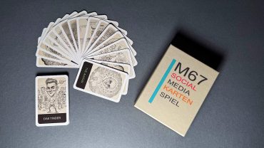 Michael Stevens zeigt eine Sammlung von Spielkarten und ein Kartenspiel-Set, das für Social Media und Medienmarketing verwendet wird, mit Fokus auf kreative Kommunikation.