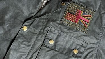 Michael Stevens trägt eine Jacke mit britischer Flagge und Markenpatch, Nahaufnahme.